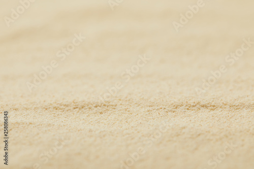 selective focus of textured sandy surface on beach in summertime