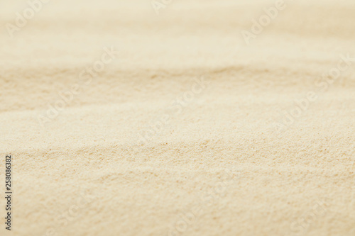 selective focus of golden sandy surface on beach in summertime