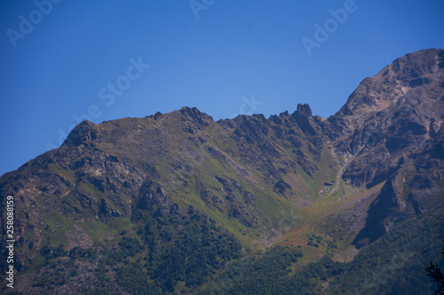 A huge panorama of high Caucasus mountains and beautiful trees on a sunny summer day. A very large amount of stones. © dmitriydanilov62