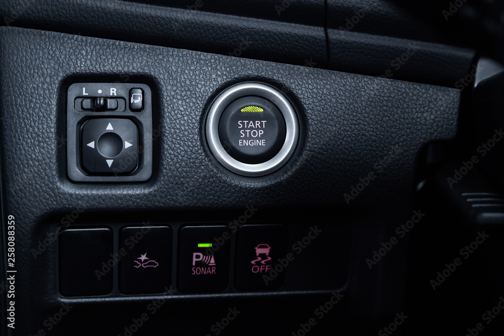 Сlose-up of the car grey interior: start stop engine button,side mirror adjustment buttons, parking systems and other buttons . Сlose-up of the car grey interior: start stop engine button,side mirror adjustment buttons, parking systems and other buttons .