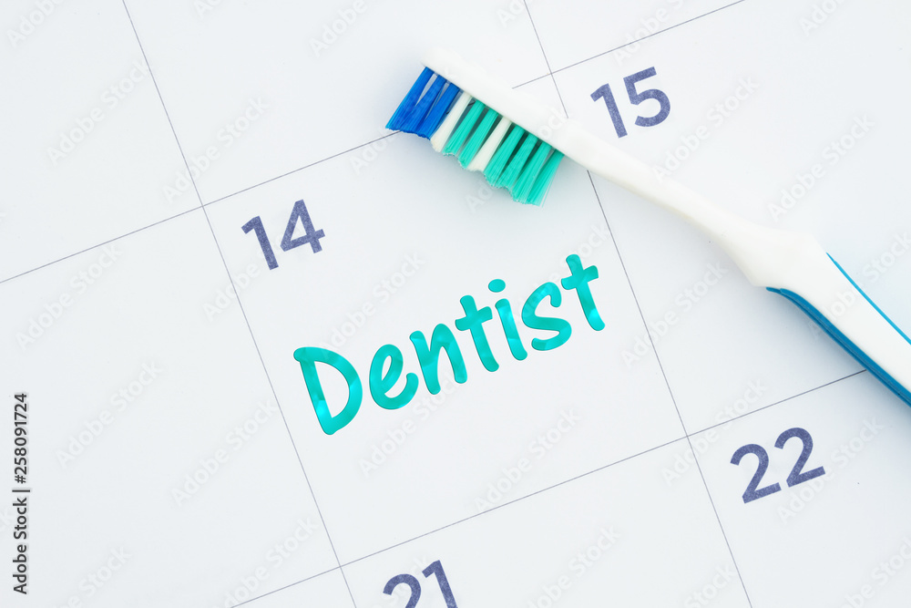 Schedule a dentist appointment message on a calendar with a toothbrush Schedule a dentist appointment message on a calendar with a toothbrush
