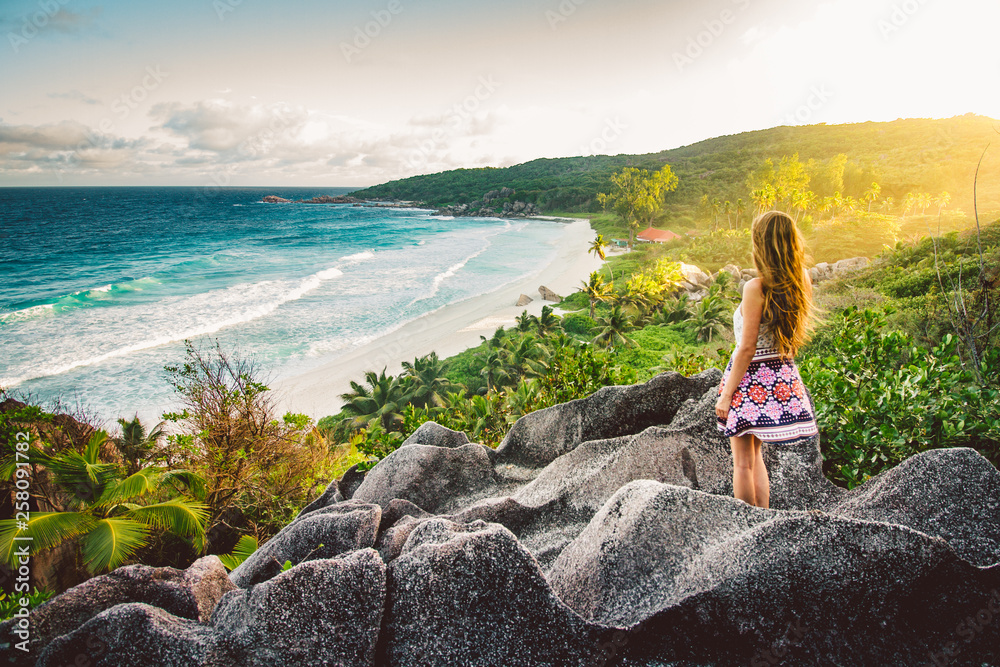 A young girl admiring the view at Grande Anse beach located on La Digue Island, Seychelles