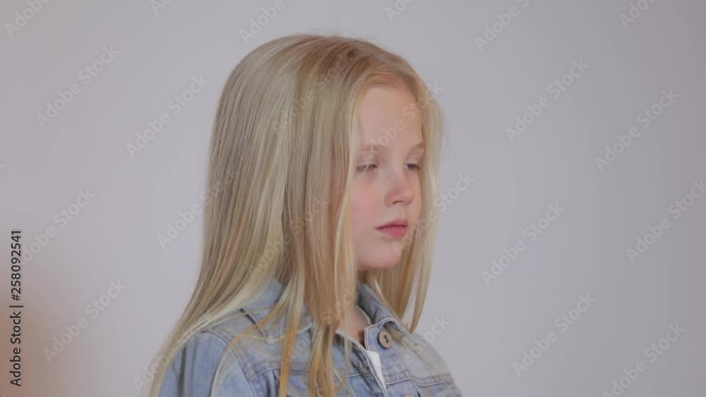 Cute blonde little girl posing in photo studio. Children's photo session on a white background. Close-up Cute blonde little girl posing in photo studio. Children's photo session on a white background. Close-up