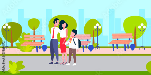 parents getting son with schoolbag from school after study happy family walking in city park boy eating ice cream back to home concept landscape background full length horizontal