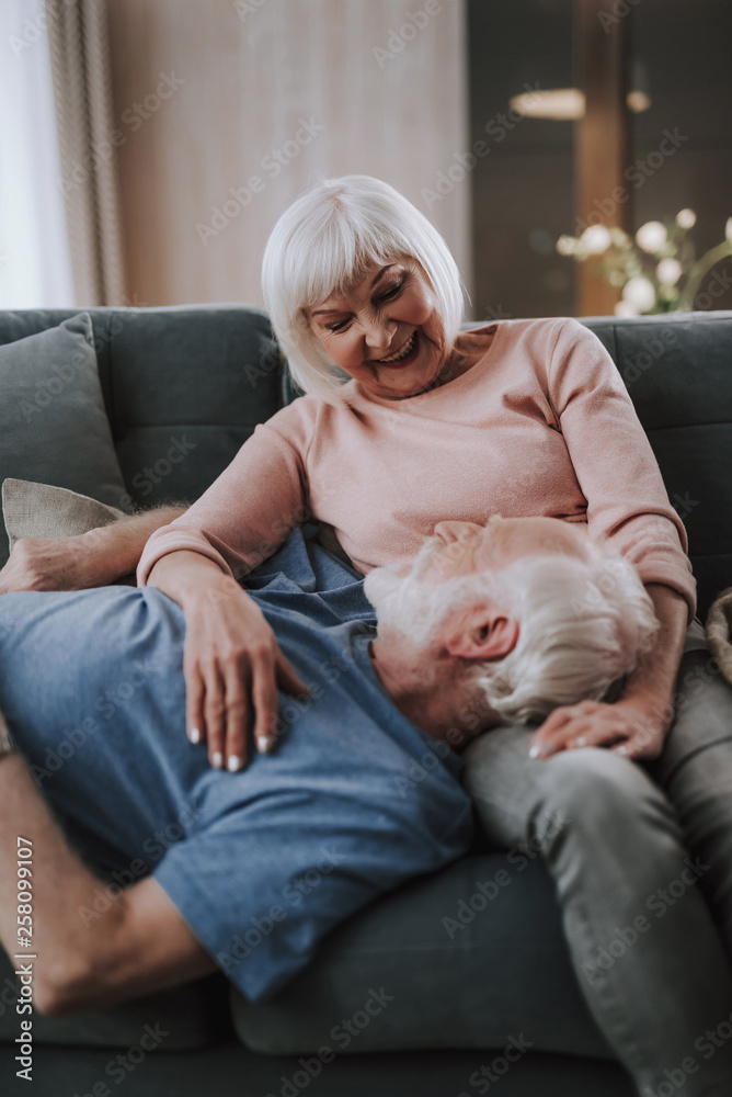 Happy elder couple enjoying time together on sofa Happy elder couple enjoying time together on sofa