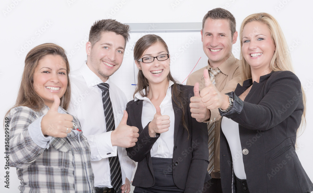 Happy business team in front of a flip chart is showing thumb up Happy business team in front of a flip chart is showing thumb up