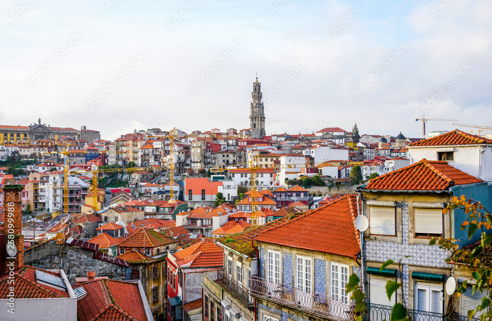 Obraz premium View from the Porto Cathedral overseeing traditional Porto houses, with tower of Clerigos Church far away in the middle.