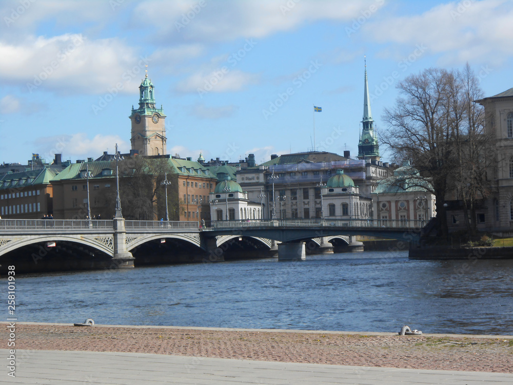 City view of the colorful buildings and streets of Stockholm with cars, river, sky with clouds. European tourism