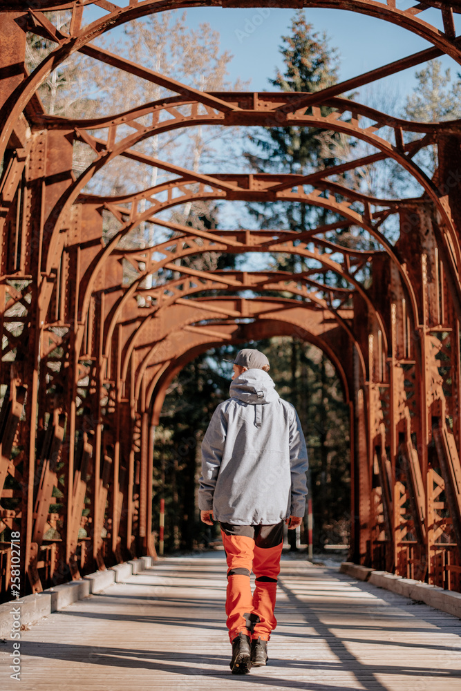 Young man walks over an old bridge in Slovenia