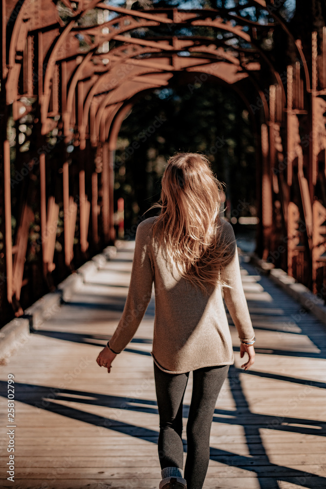 Young woman walks over an old bridge in Slovenia