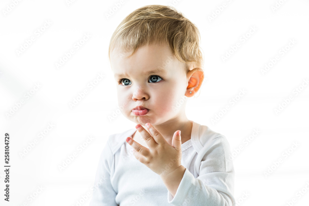 cute frowning baby with blonde hair looking away isolated on white