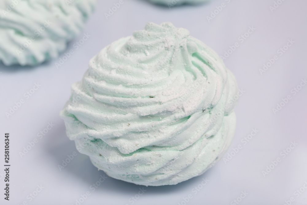 Homemade marshmallows laid on a white background. Marshmallow with mint, with a green tint. Nearby is a piece of marshmallow, its slice is visible. Homemade marshmallows laid on a white background. Marshmallow with mint, with a green tint. Nearby is a piece of marshmallow, its slice is visible.