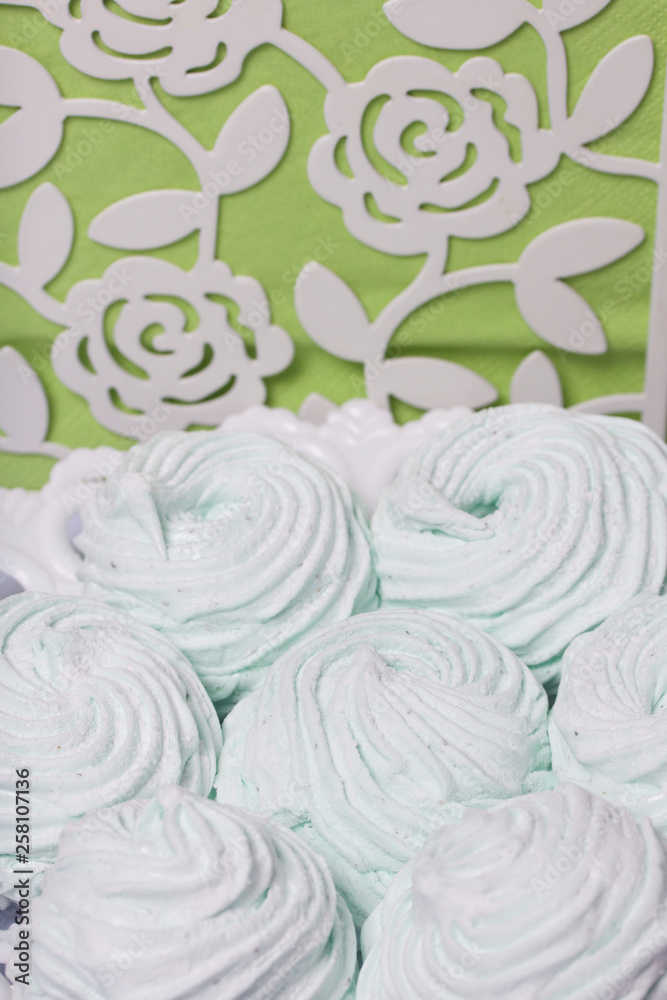 Fototapeta premium Homemade marshmallows laid on a plate. Marshmallow with mint, with a green tint. Nearby are napkins of light green color.