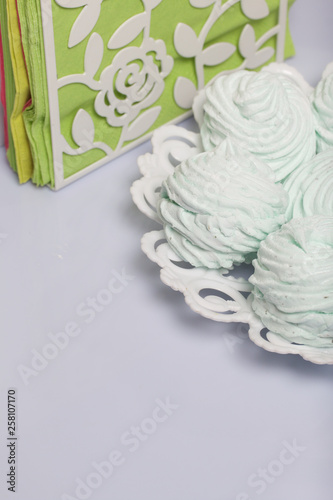 Homemade marshmallows laid on a plate. Marshmallow with mint, with a green tint. Nearby are napkins of light green color.