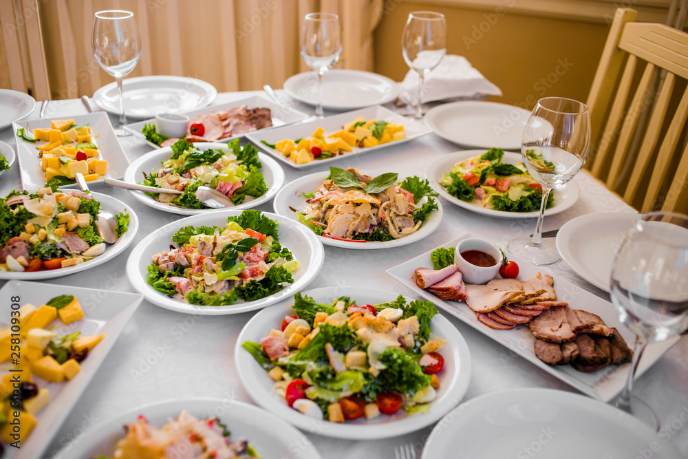 Buffet table of reception with cold snacks, meat and salads