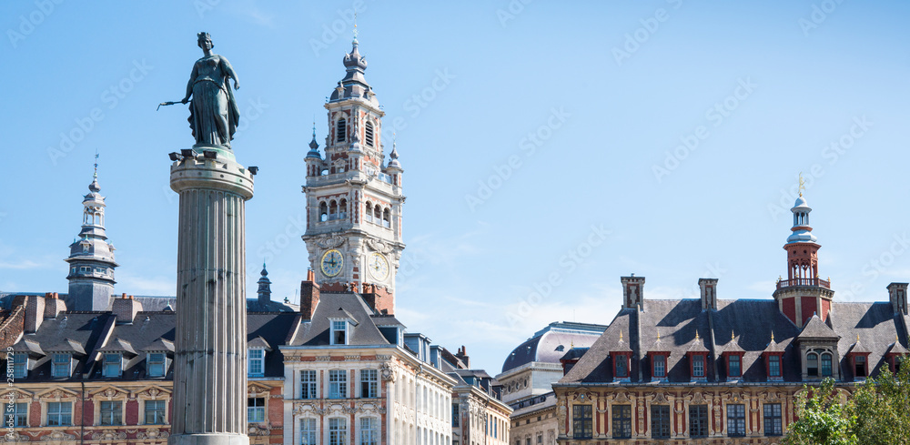 Obraz premium banner. tower of Chamber of commerce, buildings at central town square in Lille, France. white sculpture, against blue sky. space for text