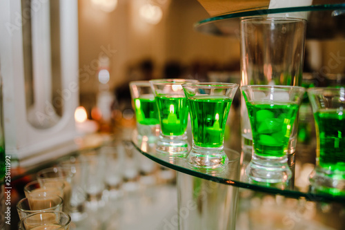 Alcoholic drinks of green color in glass cups