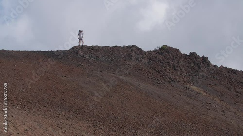 Astronaut standing on a  hilltop in a Martian landscape, Hawaii