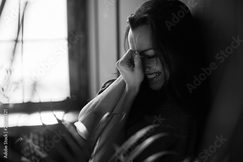 The girl sincerely laughs and closes her palms face