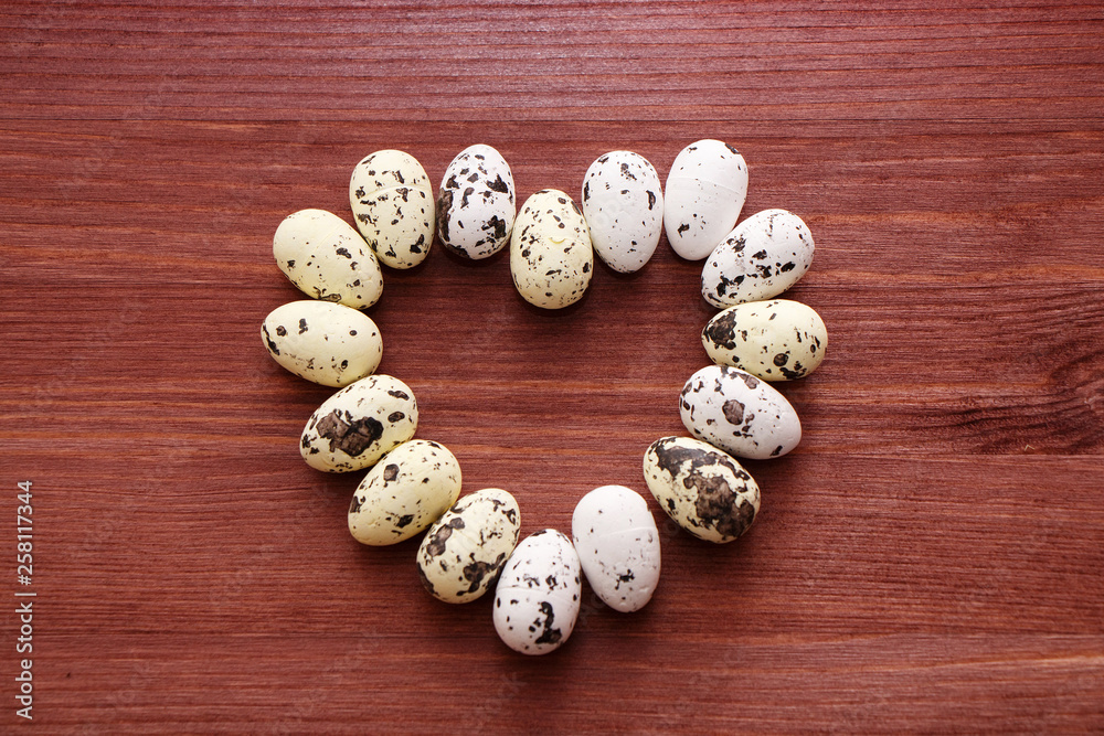 Quail eggs in the shape of a heart on a wooden table Quail eggs in the shape of a heart on a wooden table