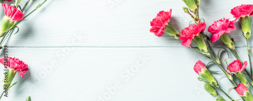Fototapeta Naklejka Na Ścianę i Meble -  Spring holidays flat lay with bouquet of pink carnation on light turquoise wooden background. Top view with copy space. Banner.