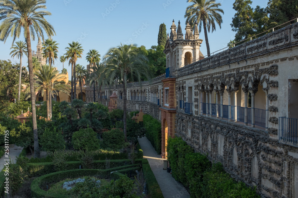 Looking alongside the ornate internal wall of the gardens inside the Royal Alcazar Complex Seville, Spain