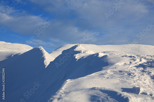 The bright blue sky above the snow-covered slopes of the mountains © Vitalfoto