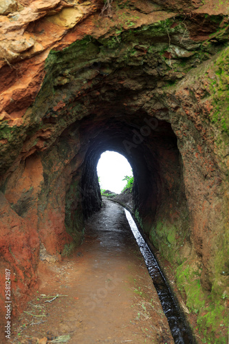 Beautiful view of a waterway tunnel during a levada hike on the island Madeira