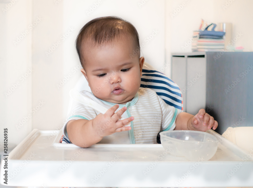 Baby playing with spoon and feeding bowl Baby playing with spoon and feeding bowl