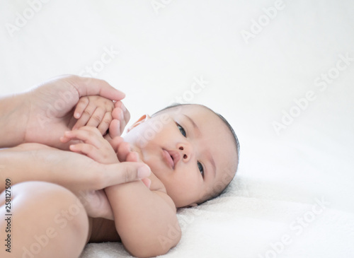 Mother hands touching baby with love and care, Asian baby girl after shower on the white background
