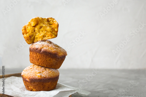 homemade orange pumpkin cupcakes with powdered sugar on a grey background. copy space. the view from the top.minimalist composition
