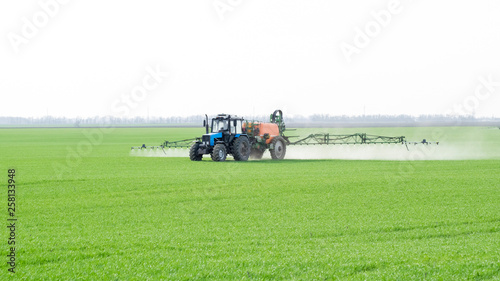 Tractor with a spray device for finely dispersed fertilizer.