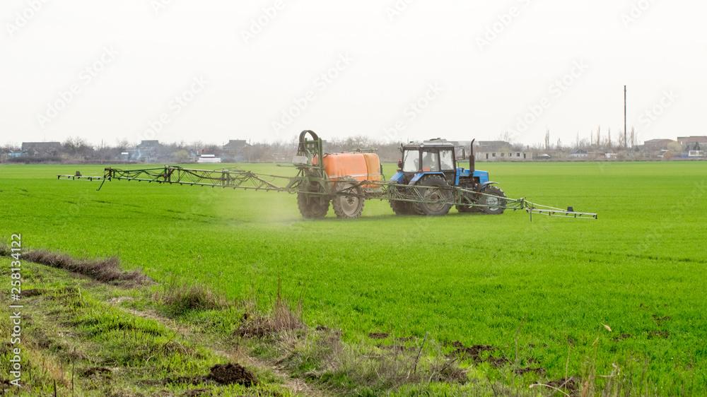 Fototapeta premium Tractor with a spray device for finely dispersed fertilizer.
