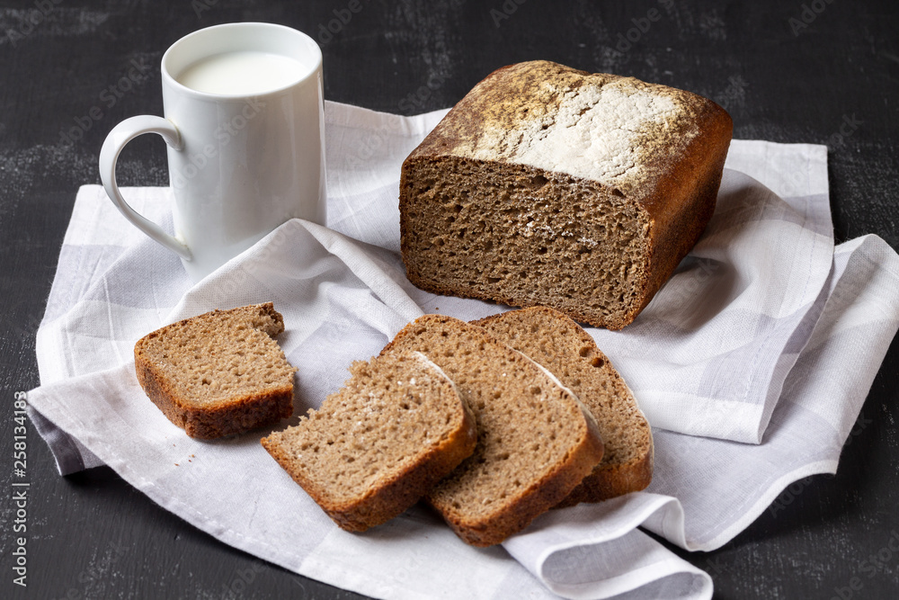 Form rye-wheat bread, sliced, and a mug of milk. Form rye-wheat bread, sliced, and a mug of milk.