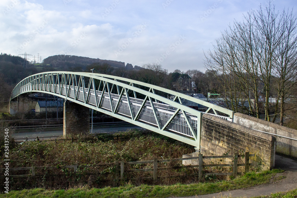 An elegant footbridge swoops across both road and railway