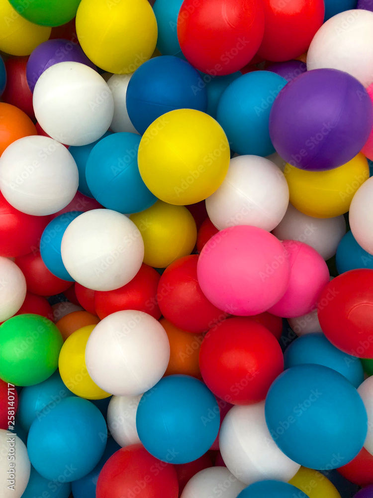 Top view colorful plastic balls in a pool. Plastic colorful balls for playing. Colorful plastic gum balls background in kid playroom or playground for children's holiday party concept