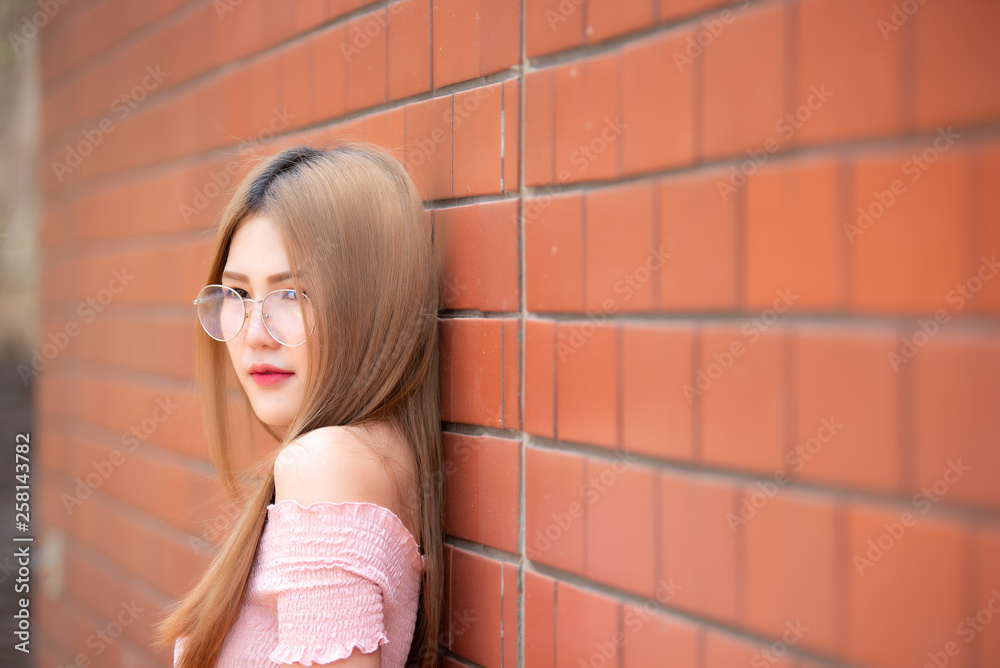 Fototapeta premium Portrait of beautiful asian chic girl wear black dress pose for take a picture on brick wall,Lifestyle of teen thailand people,Modern woman happy concept,Korea style
