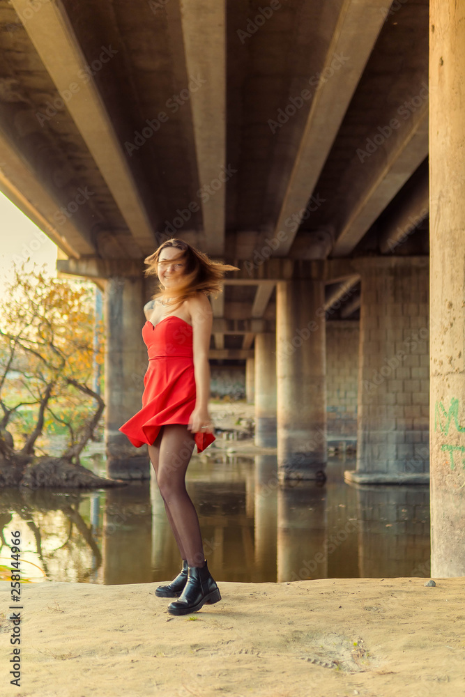 A woman is posing in front of a camera in an autumn park. autumn photo shoot. Autumn in the park.