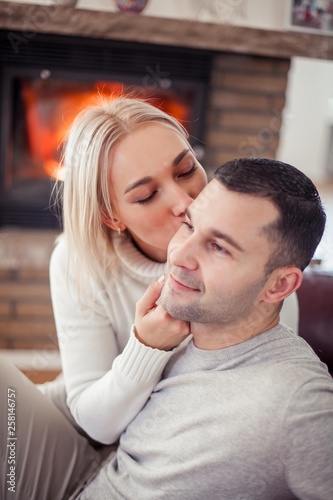 Young beautiful couple is sitting near the fireplace. Cozy. © Kristina89
