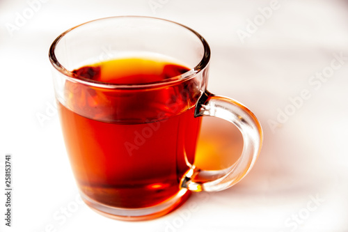 Glass cup filled with black tea isolated on a white background