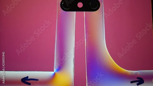 Two coupled angle braces one with sharp inner edge, one with soft inner edge, are exposed to a tractive force (aa arrows). Polarized light makes the stress to the braces visible.