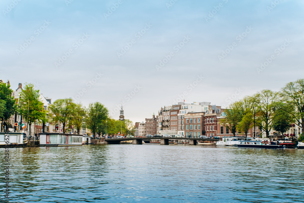 Amsterdam, Netherlands September 5, 2017: Reflection of trees and houses in still water of Amstel river, Amsterdam, Netherlands.