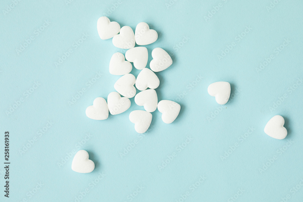 Pills as a heart on blue background