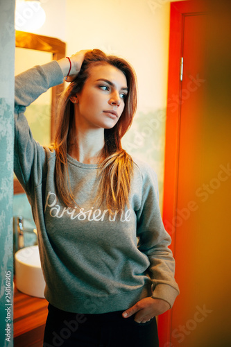 Photo of woman looking to side against background of doors indoors