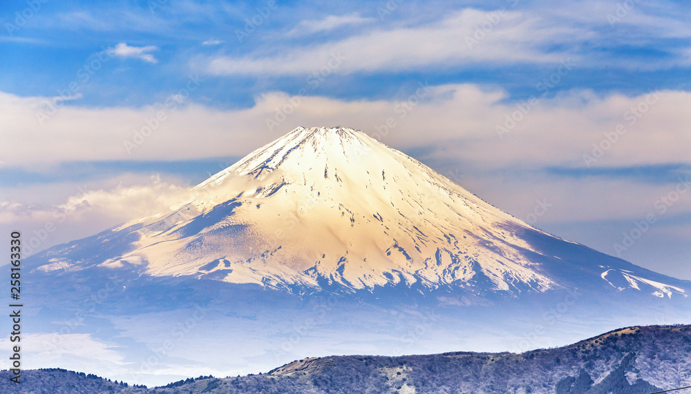 View of Fuji mountain, with snow cover on the top sunlit at sunset, golden hours. Travel Japan.