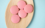 medicine tablets on a wooden spoon isolate on blue background.