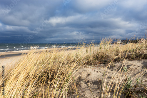 Grassy sand dunes with dramatic sky on the Baltic Sea on the island of Usedom. Germany