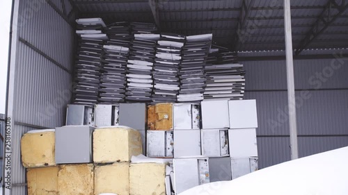 a mountain of old refrigerators in a factory in winter