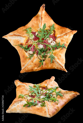 Star-shaped pizza with ham and arugula on black background