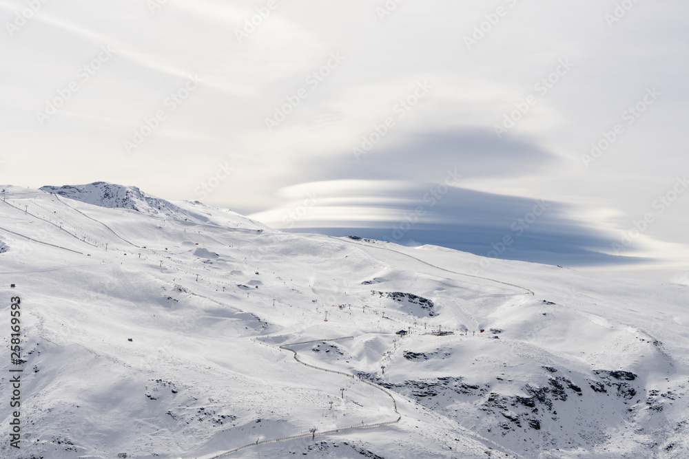 Spain, Andalusia, province of Granada, ski resort of Sierra Nevada in winter with lenticular cloud Spain, Andalusia, province of Granada, ski resort of Sierra Nevada in winter with lenticular cloud
